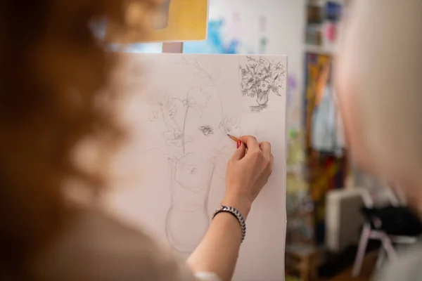 Närbild av kvinna bär armband ritning vas med blommor — Stockfoto