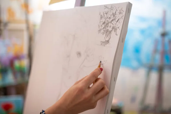 Close up of artist with red nails drawing on white canvas — Stock Photo, Image