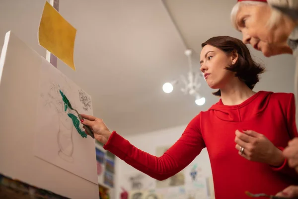 Dark-haired art student with bob cut coloring picture — Stock Photo, Image