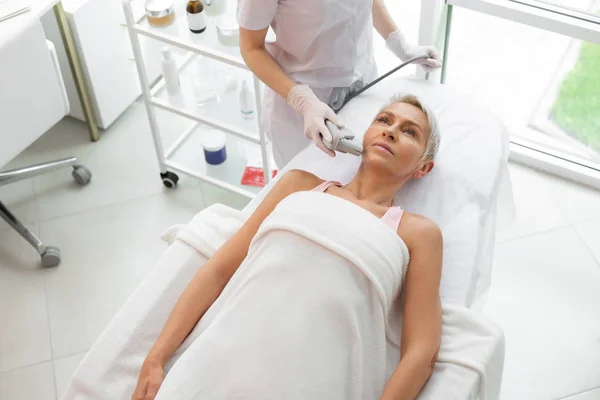 Serious mature woman receiving a dermadrop TDA procedure — Stock Photo, Image