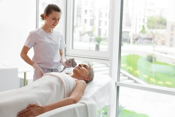 Positive freundliche Frau lächelt ihrer Patientin zu — Stockfoto