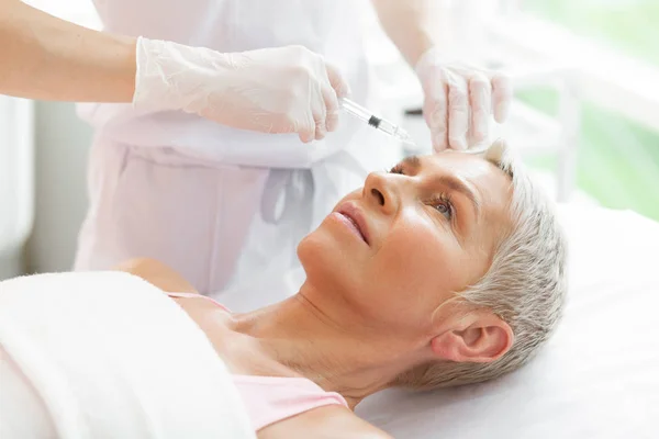 Nice good looking woman during the procedure of botox injections — Stock Photo, Image
