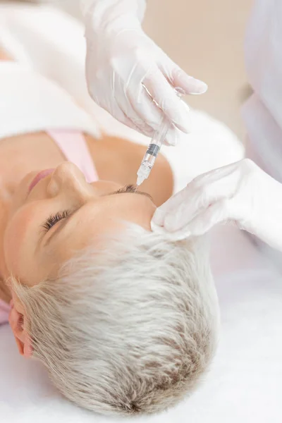 Hands of a professional skilled cosmetologist being in gloves — Stock Photo, Image