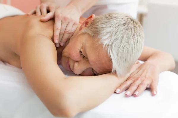 Nice good looking woman enjoying the shoulder massage — Stock Photo, Image