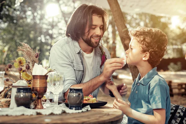 Bello uomo dai capelli lunghi seduto con suo figlio — Foto Stock