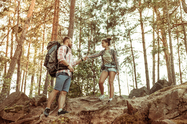 Pleasant nice couple standing on the rocks