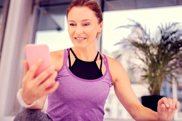 Olumlu memnun yaşlı kadın onu gadget bakıyor