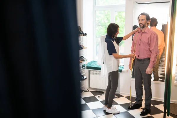 Oogverblindend consultant het krijgen van metingen van de klant in de paskamer. — Stockfoto