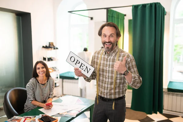 Šťastný dospělý vousatý muž s otevřeným znamením v ruce — Stock fotografie