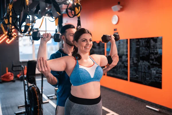 Mujer obesa haciendo ejercicios con pesas con ayuda de entrenador — Foto de Stock