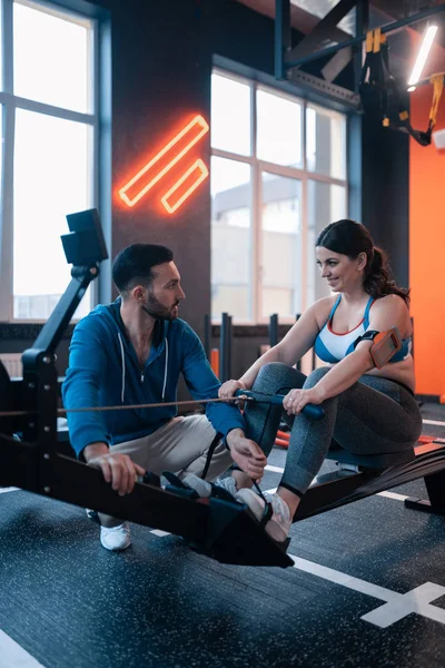 Mujer con ligera obesidad sonriendo mientras habla con el entrenador — Foto de Stock