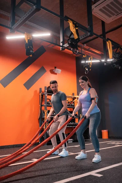 Onun eğitmen yakınında Trx ile egzersiz kilolu kadın