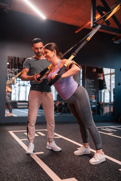 Mujer con sobrepeso sintiéndose positiva tratando de TRX ejercicios para brazos — Foto de Stock