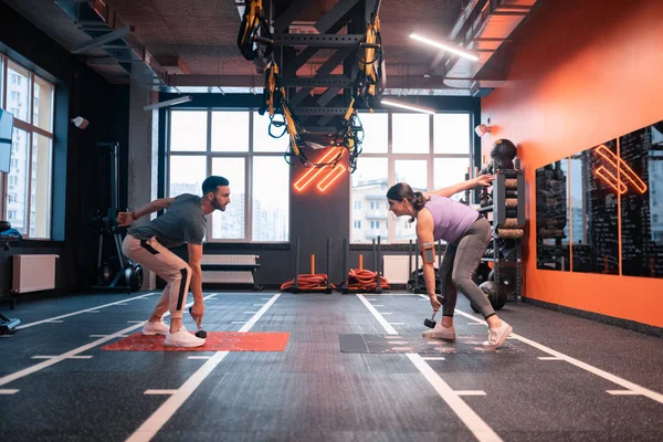 Bärtiger Trainer zeigt seinem Klienten Übungen mit Langhanteln — Stockfoto