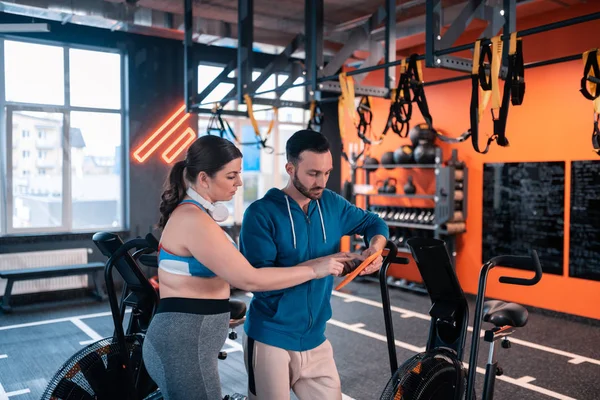 Entrenador recomendando a su cliente entrenamientos en línea útiles — Foto de Stock