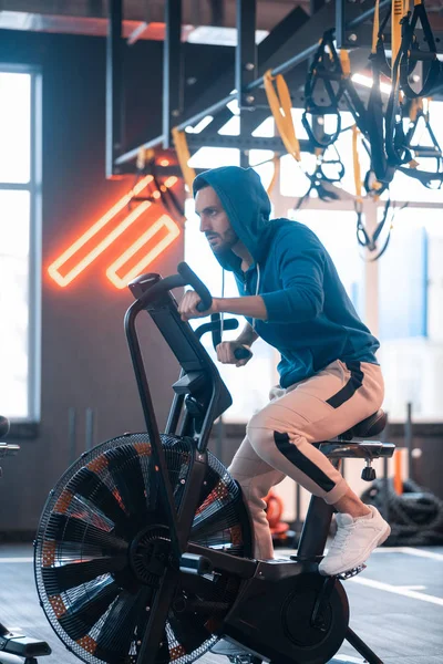 Bonito homem de negócios vestindo roupas esportivas de ciclismo no ginásio — Fotografia de Stock