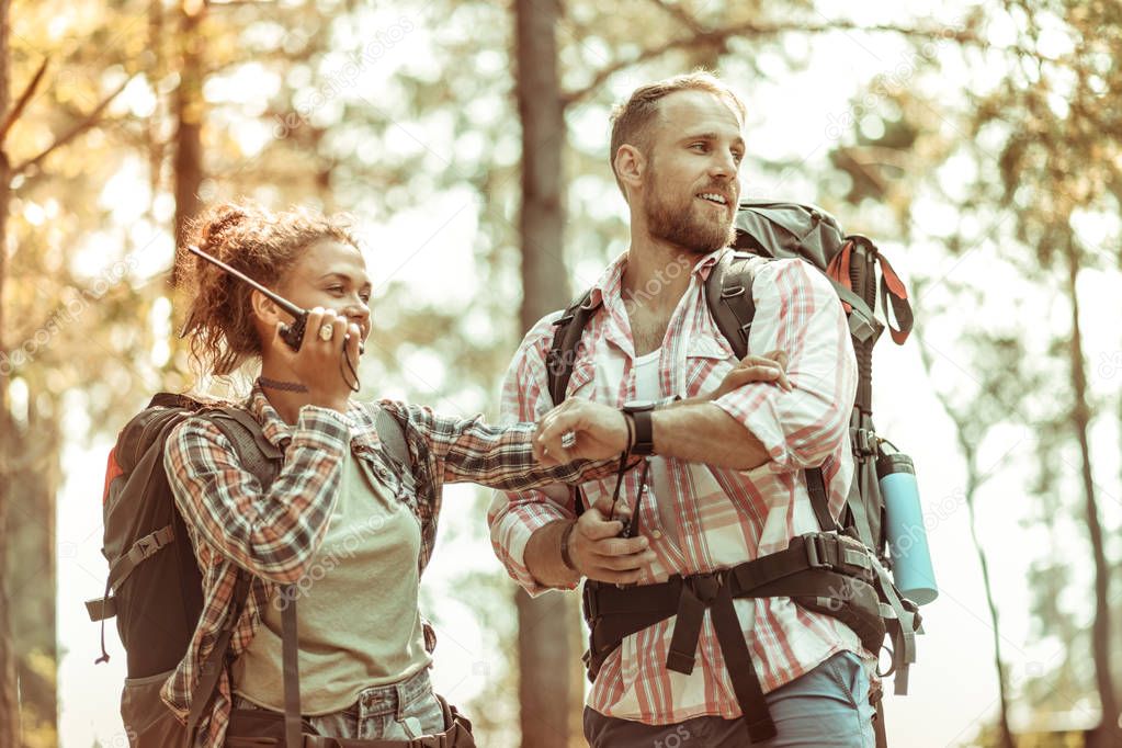 Joyful positive couple speaking on the portable radio