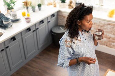 Bir bardak su ile düşünceli hamile kadın.