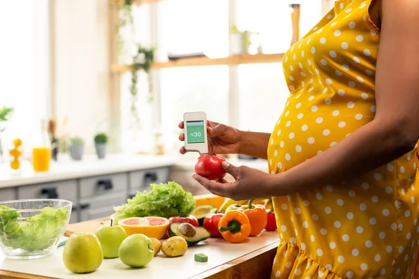 Zwangere vrouw staande voor de keuken tafel. — Stockfoto