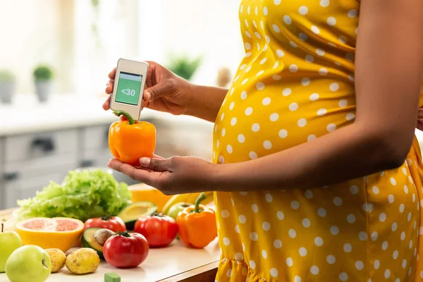 Mujer embarazada midiendo nitratos en un pimiento dulce . — Foto de Stock