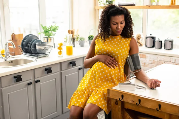 Serious pregnant woman during blood pressure measurement. — Stock Photo, Image