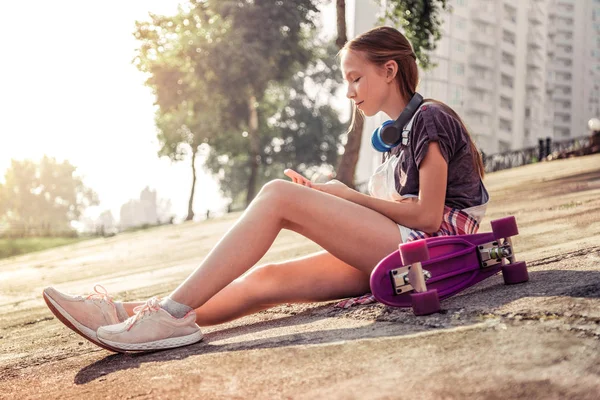 Peaceful young girl sitting on the ground during summer holidays — Stock Photo, Image