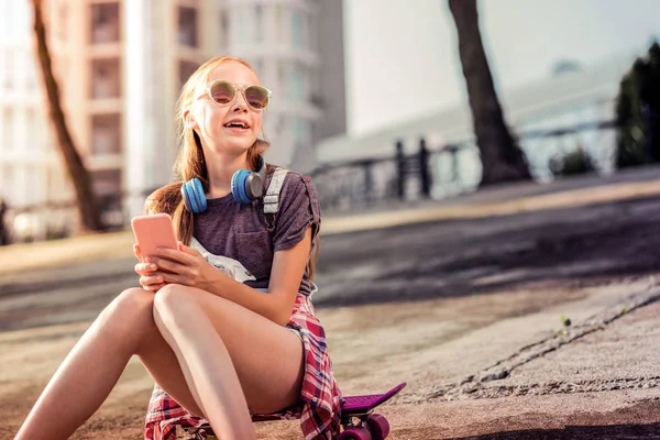 Chica joven activa en gafas de sol que se enfría solo mientras está sentado —  Fotos de Stock