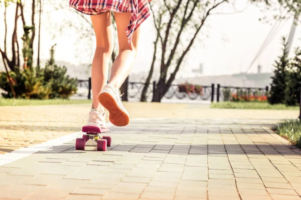 Little active girl in checkered shirt picking up speed while riding — Stock Photo, Image