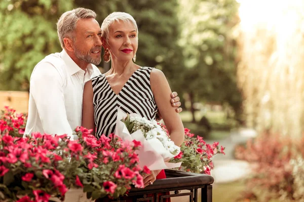 Schöner Mann umarmt seine Frau im gestreiften Kleid — Stockfoto