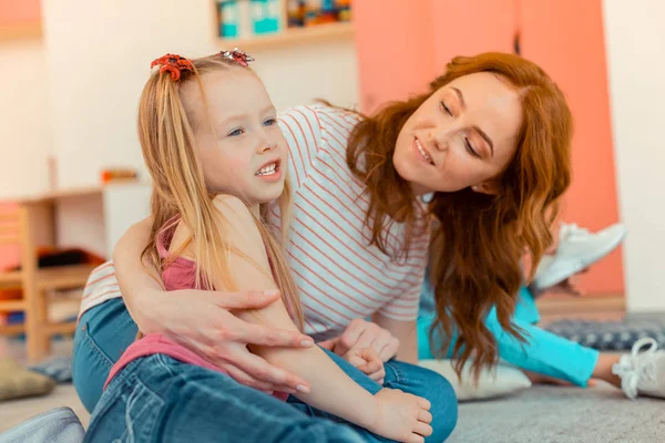 Aangename mooie vrouw probeert te krijgen samen met een meisje — Stockfoto