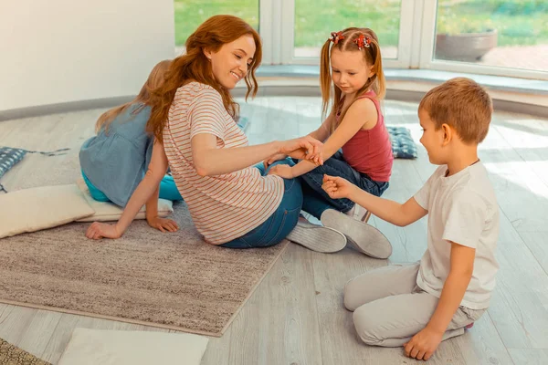 Joyful trevlig kvinna leker tillsammans med barn — Stockfoto