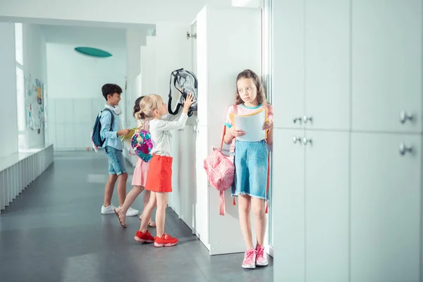 Children using their school lockers while having break from lesson