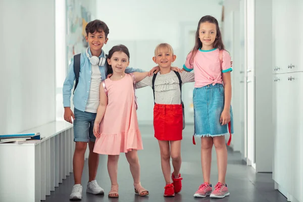 Three girls and one boy hugging while feeling good together — Stock Photo, Image