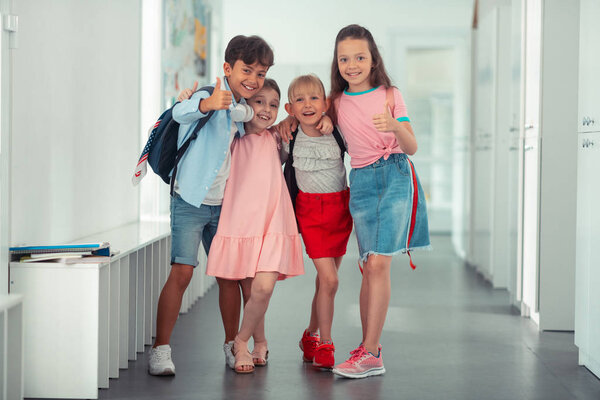 Cheerful pupils feeling happy after finishing school year