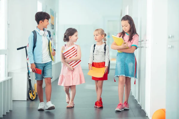 Jongen en meisjes gaan naar klaslokaal en bespreken schema — Stockfoto