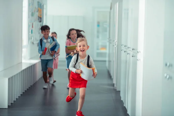 Lycklig tjej klädd i röd kjol som kör hem från skolan — Stockfoto