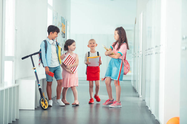 Cheerful stylish children going to the classroom together
