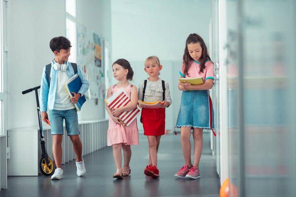 Children holding their notebooks while going to the lesson