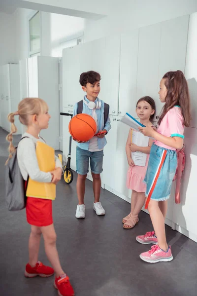 Темноволосий хлопчик тримає баскетбол розмовляючи з дівчатами — стокове фото