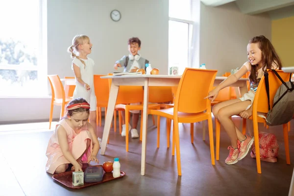 Niños intimidación niña pequeña bandeja con comida en la cantina — Foto de Stock