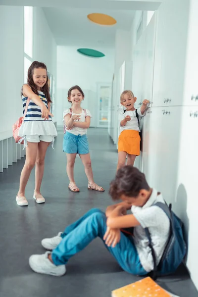 Rude våldsamma tjejer skrattar åt mörkhåriga pojke i skolan — Stockfoto