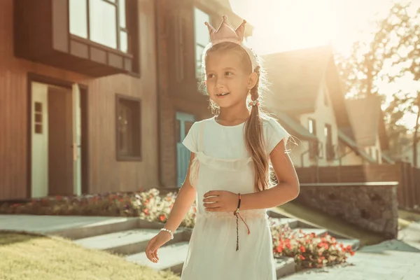 田舎を歩くピンクの王冠のかなり長い髪の子供 — ストック写真