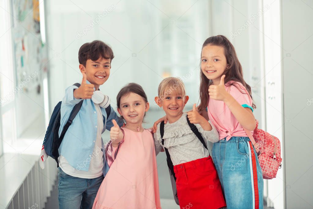 Cute children wearing stylish clothes showing thumbs up