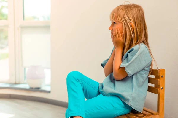 Nettes süßes Mädchen sitzt auf dem Stuhl — Stockfoto