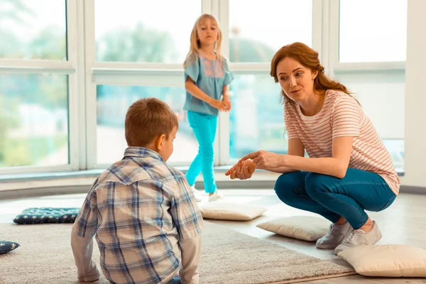 Aangename vriendelijke vrouw glimlachend naar het kind — Stockfoto