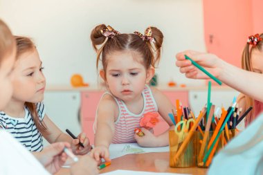 Renkli bir kalem alarak sevimli güzel kız