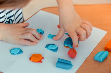 Plastik parçaya basan çocuk elinin üst görünümü