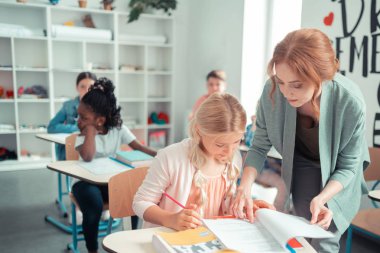 Bir öğrenciye ihtiyaç verici egzersiz gösteren özenli öğretmen.