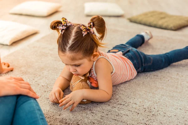 Гарна мила дівчина дивиться на килим — стокове фото
