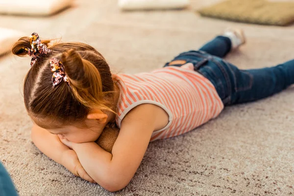 Infelice stanca ragazza guardando il tappeto — Foto Stock